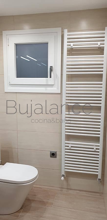 Zona de sanitario compacto de diseño y toallero lacado en blanco en reforma de baño moderna en Benasque